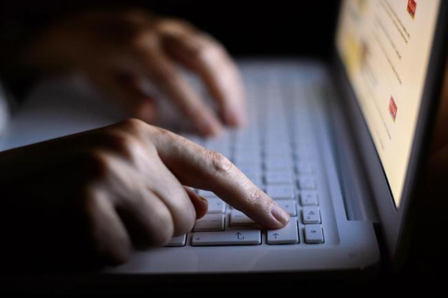 Image shows hands of somebody typing on a computer